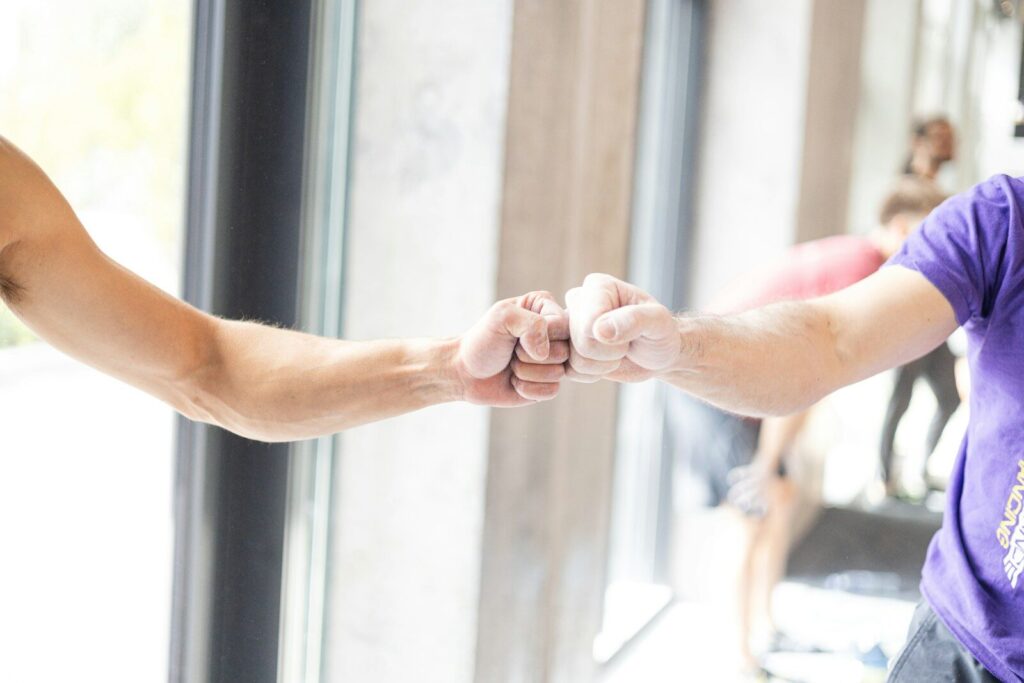 Two people fist bumping in a gym